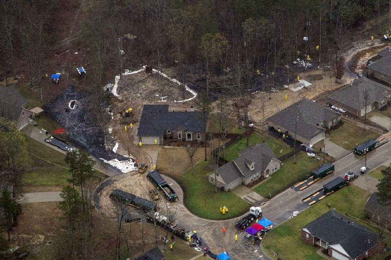 FILE—Workers clean up oil spilled by a ruptured Exxon Mobil pipeline in Mayflower in this 2013 file photo.