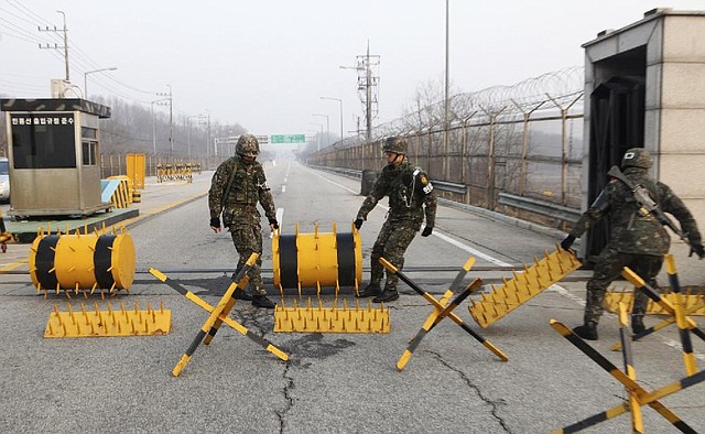 South Korean soldiers move barricades to let vehicles pass at a military checkpoint Thursday in Paju near the border village of Panmunjom. North Korea on Wednesday barred South Korean workers from entering a jointly run factory park just across the heavily armed border in the North, officials in Seoul said. 