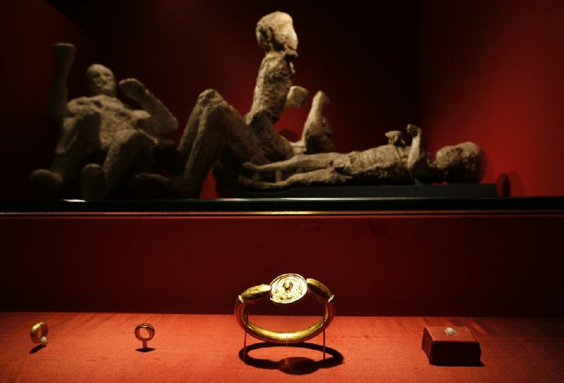 Jewelry found in the ruins of a house in Pompeii is back dropped by the casts of a family with two adults and two children. The casts were made by pouring plaster in the void left by their bodies. 