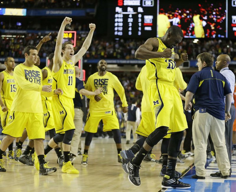 Guard Tim Hardaway Jr. (right) and his Michigan teammates celebrate following the Wolverines’ 61-56 victory over Syracuse on Saturday at the Georgia Dome in Atlanta. They will face Louisville on Monday for the national championship. 