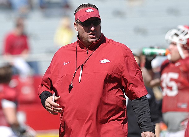 Arkansas coach Bret Bielema watches the Razorbacks warm up during practice Saturday morning at Razorback Stadium in Fayetteville. 