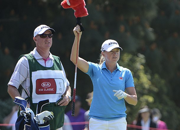 Stacy Lewis, right, chooses a club with her caddy Travis Wilson, left, before hitting her tee shot on the second hole during the final round of the LPGA Kia Classic golf tournament at the Aviara Golf Club on Sunday March 23, 2013 in Carlsbad, Calif. (AP Photo/Denis Poroy)