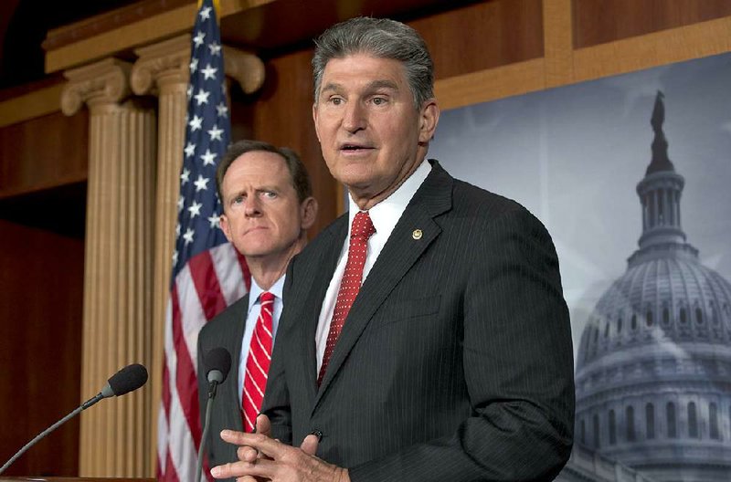 Sen. Patrick Toomey (left) and Sen. Joe Manchin announce agreement Wednesday on a plan to expand background checks that Toomey said was “just common sense.” 