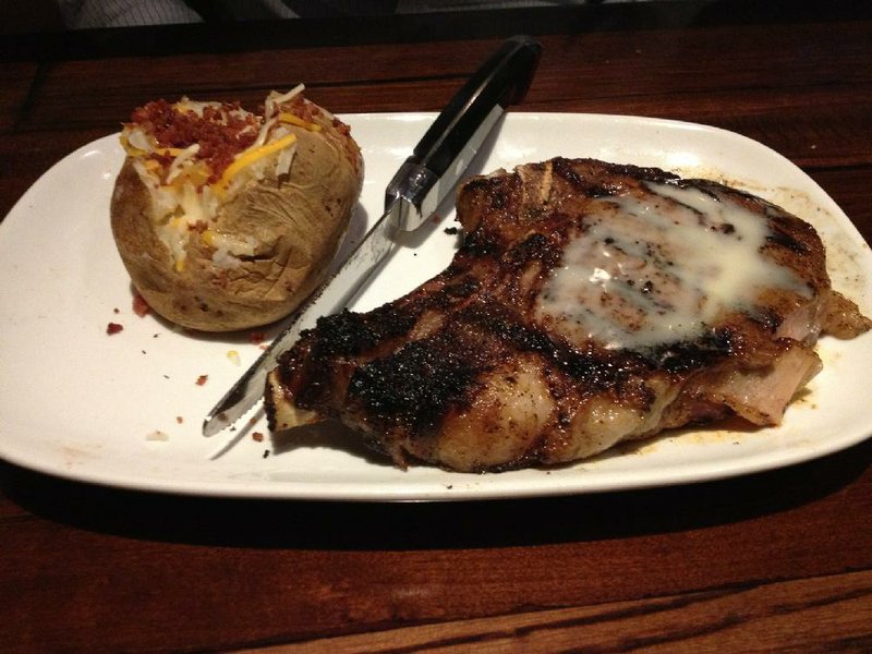 The Outlaw Ribeye, served here with a loaded baked potato, weighs in at 18 ounces at LongHorn Steakhouse in west Little Rock. 