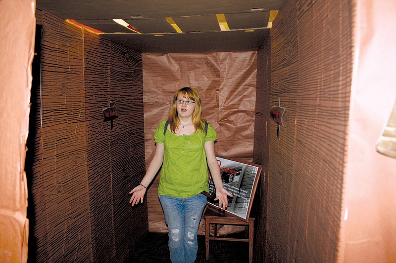 Emma Callahan of Malvern Middle School stands in a representation of a railroad car like those used to carry “undesirable” people to concentration camps under the rule of the Nazis in the 1930s and 1940s. The exhibit was one of many on display last week at the school to teach other Malvern students about the Holocaust.
