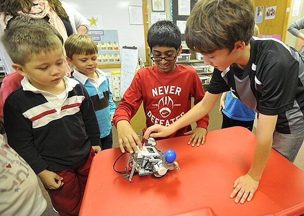 The New School pre school students (left to right) Alexander Ivannikov and Eli Clark, watch with their classmates as 5th graders Kaushik Sampath and Storm Skyrme demonstrate their robotic lego creations Friday afternoon at the school.  The New School in Fayetteville is planning on an expansion of their school.