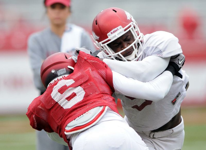 NWA MEDIA/SAMANTHA BAKER
University of Arkansas wide receiver D'Arthur Cowan, left, fights off cornerback Will Hines during practice drills Saturday, April 13, 2013, at Razorback Stadium in Fayetteville