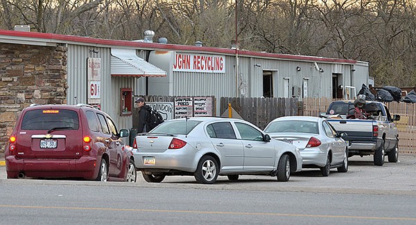 Customers wait in line at Vaughn Recycling on 1246 S School Street in Fayetteville Saturday morning as they wait it to open so they can sell their recyclable materials.  Vaughn Recycling buys a variety of scrap metals for recycling.