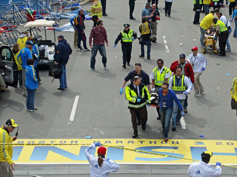 Medical workers wheel the injured across the finish line during the 2013 Boston Marathon following an explosion in Boston, Monday, April 15, 2013. Two explosions shattered the euphoria of the Boston Marathon finish line on Monday, sending authorities out on the course to carry off the injured while the stragglers were rerouted away from the smoking site of the blasts.