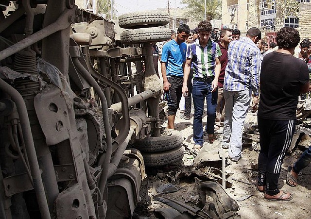 Civilians gather at the scene of a car bomb attack in east Baghdad's neighborhood of Kamaliya, Iraq, Monday, April 15, 2013. Less than a week before Iraqis in much of the country are scheduled to vote in the country's first elections since the 2011 U.S. troop withdrawal, a series of attacks across Iraq, many involving car bombs, has killed and wounded dozens of people, police said. (AP Photo/ Khalid Mohammed)