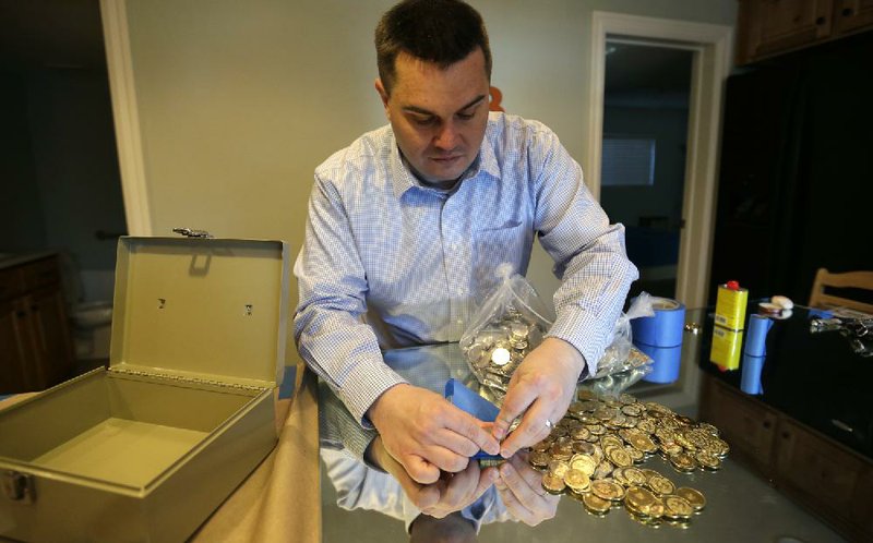 Mike Caldwell, 35, a software engineer, examines bitcoin tokens he mints at his shop in Sandy, Utah, cranking out the tokens that have codes protected by tamper-resistant holographic seals. 