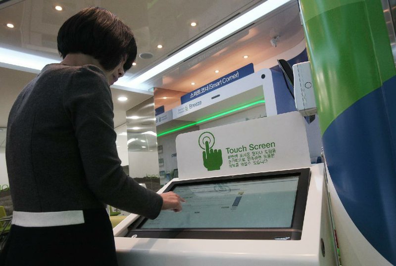 Customer Eun-young uses a computer monitor for a transaction at a Standard Chartered Bank Smart Banking Center in Seoul, South Korea. 