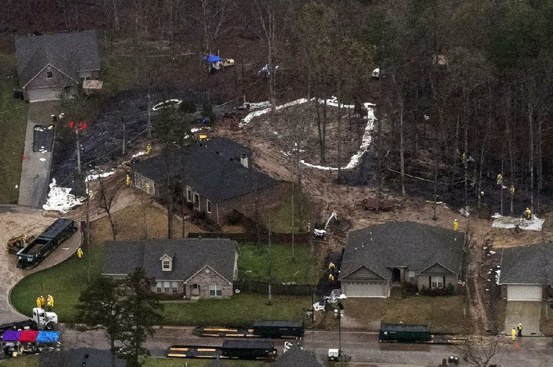 FILE PHOTO: Workers clean up oil in a residential area of Mayflower after 2013's pipeline rupture.