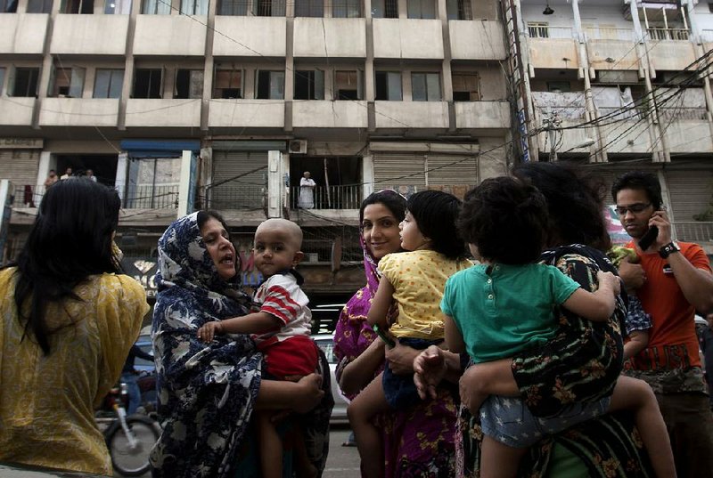 People evacuate buildings and gather on road as tremor of an earthquake was felt in Karachi, Pakistan, Tuesday, April 16, 2013. A major earthquake described as the strongest to hit Iran in more than half a century flatted homes and offices Tuesday near Iran's border with Pakistan, killing at least tens of people in the sparsely populated region and swaying buildings as far away as New Delhi and the skyscrapers in Dubai and Bahrain. (AP Photo/Shakil Adil)