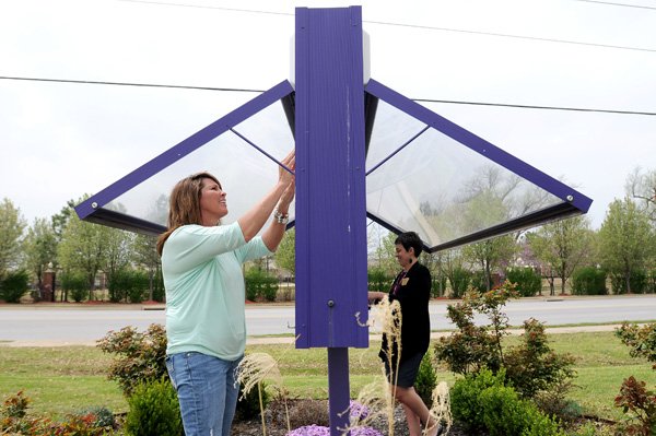 Rachael Wehn, right, secretary at Walker Elementary School and Tina Horsey, parent and volunteer at the school, change the messages Tuesday on the sign in front of the school in Springdale. The sign will advertise events through the end of April and the beginning of May. Horsey has two children at the school and volunteers her time at the school. 
