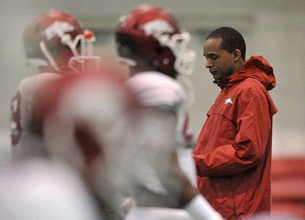 Arkansas linebackers coach Randy Shannon (right) watches a spring practice on March 30, 2013 in Fayetteville. 