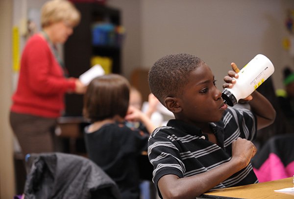 Lonnie Rice, a fourth-grader at Asbell Elementary School in Fayetteville, right, drinks from a water bottle Thursday, April 11, 2013, while listening to teacher Pat Shepard's lesson on the digestive system at the school.