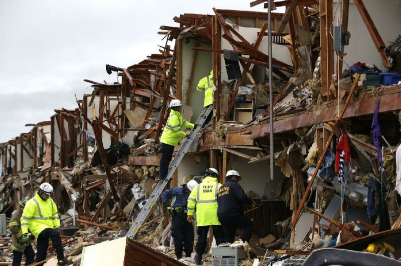Firefighters search through the ruins of an apartment complex destroyed Wednesday night when the West Fertilizer Co.’s plant in West, Texas, exploded, killing as many as 15 people and injuring more than 160, officials said. 