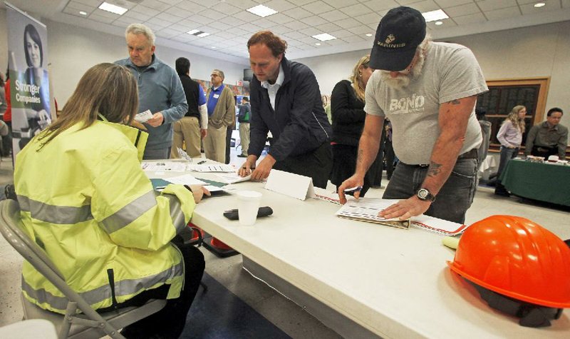 Job seekers fill out applications at a job fair in Montpelier, Vt., on April 3. The Labor Department said Thursday that the number of Americans seeking unemployment benefits rose 4,000 last week to a seasonally adjusted 352,000. 