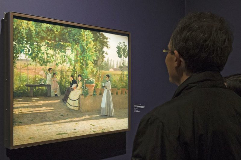 A visitor looks at the painting After Lunch (La Pergola), 1868, by Silvestro Lega, at the Orangerie Museum in Paris. 