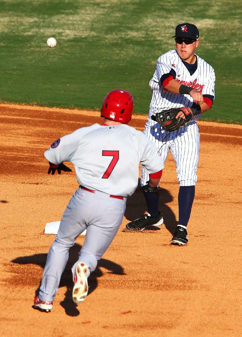 Arkansas Travelers second baseman Taylor Lindsey turns a double play as Springfield left fielder Mike O’Neill approaches second during the first inning of the first game of Friday’s doubleheader at Dickey-Stephens Park in North Little Rock. The Travs lost 3-2. 