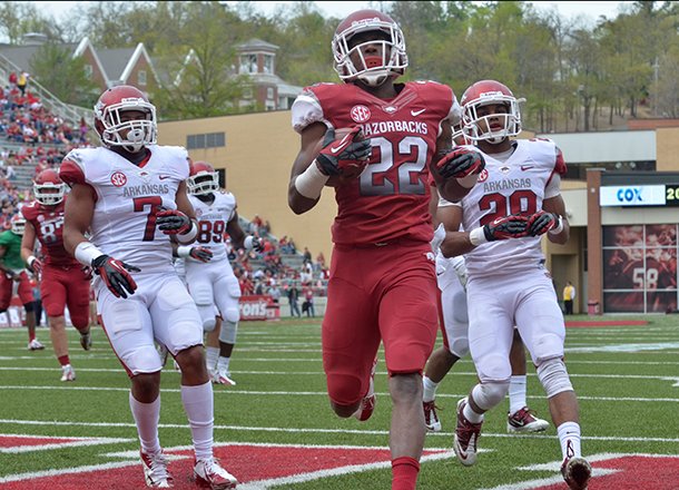 Arkansas running back Nate Holmes beats defenders Tiquention Coleman (left) and Ray Buchanan Jr. to the end zone as he scores a touchdown during the Razorbacks' Red-White scrimmage. Holmes will have a role on the kickoff return team.