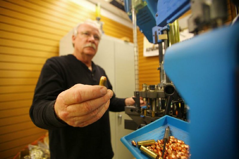 Steve Sturm, owner of Sturm’s Indoor Gun Range in Springdale, shows a finished .45 caliber round produced by a Dillon Super 1050 ammunition press, one of several presses he sells. As factory-manufactured ammunition has become increasingly scarce in Arkansas and across the country, many gun owners are turning to reloading their own ammunition. 