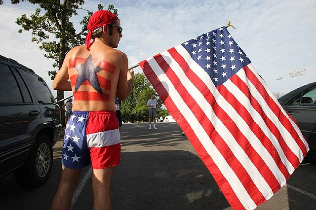 Jacob Wells rolls up the U.S. flag he carried in the 2007 Firecracker Fast 5K in Little Rock. 