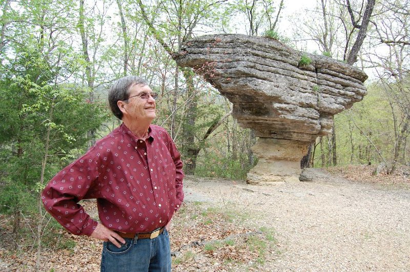 Bill Goff stands next to Pivot Rock, a tourist attraction in Eureka Springs that’s on 95 acres of land Goff is selling. The property has been in his wife’s family since 1926. 