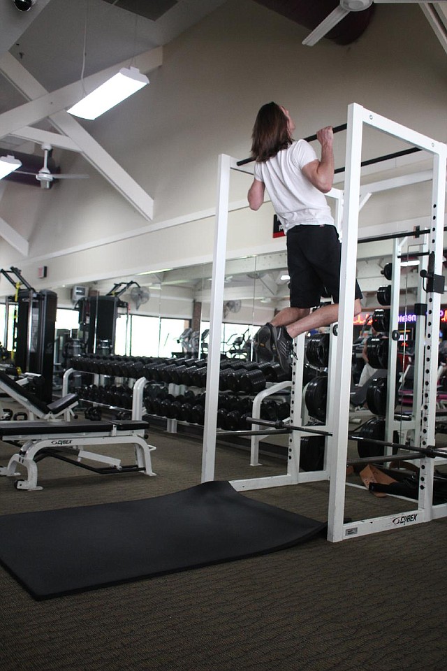 Paul Fajer, a personal trainer at Little Rock Athletic Club, had no problem whatsoever doing the Burpee Pull-up, but exercisers who lack his strength, height and experience can modify the exercise by replacing the pull-ups with a leap to touch the bar. 