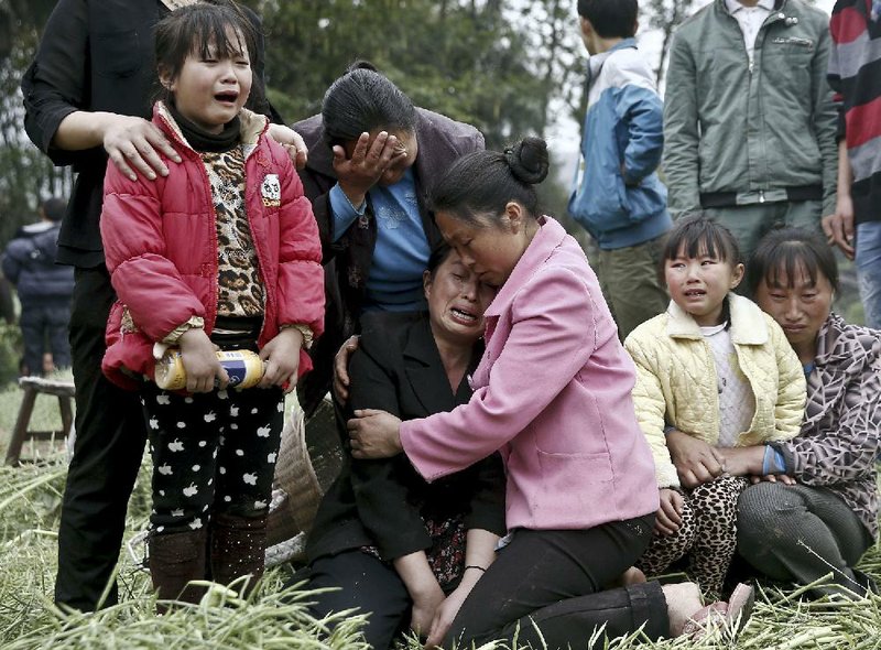 Villagers mourn during a funeral Sunday for relatives who were killed in an earthquake in Longmen village in Lushan County in southwest China’s Sichuan province. 