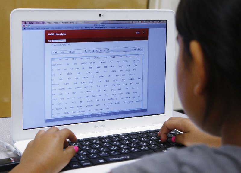 Kara Hawzipta works on a computer in a classroom at the Cherokee Nation Immersion School in Tahlequah, Okla. Experts say a growing number of tribes are trying to revitalize their languages and are frequently enlisting technology in the effort. 