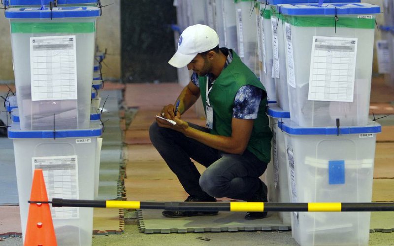 An electoral worker inspects ballot boxes at a vote-counting center in Basra, Iraq, on Sunday. 