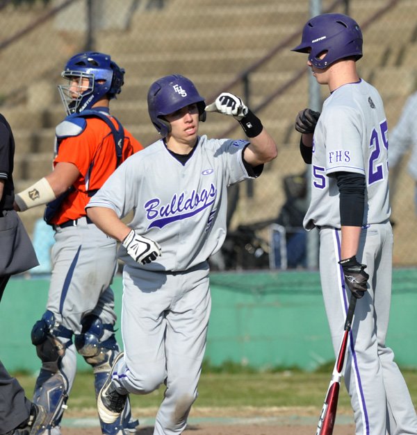 Carson Shaddy, left, of Fayetteville gets a high five from teammate Brett Price on March 27 as he scores a run on a solo home run in the third inning against Rogers Heritage at Fayetteville High School.