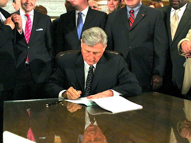Gov. Mike Beebe signs "private option" bills into law Tuesday.