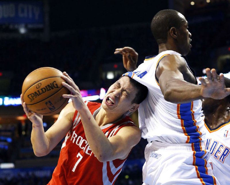 Houston Rockets guard Jeremy Lin, left, grimaces as he is fouled by Oklahoma City Thunder forward Serge Ibaka, right, in the first quarter of Game 1 of their first-round NBA basketball playoff series in Oklahoma City, Sunday, April 21, 2013. (AP Photo/Sue Ogrocki)