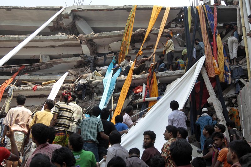 Rescue workers use clothes to bring down survivors and bodies after an eight-story building housing several garment factories collapsed in Savar, near Dhaka, Bangladesh, Wednesday, April 24, 2013. The building collapsed near Bangladesh's capital Wednesday morning, killing dozens of people and trapping many more in the rubble, officials said.
