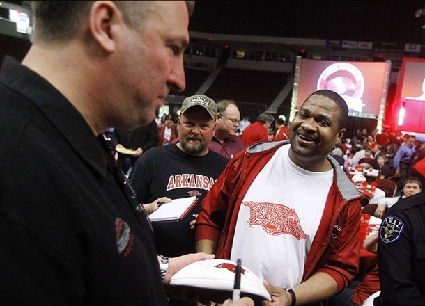 Arkansas football coach Brett Bielema signs autographs for Tim Williams and other fans and supporters during a fund raising program at Verizon Arena in North Little Rock. 