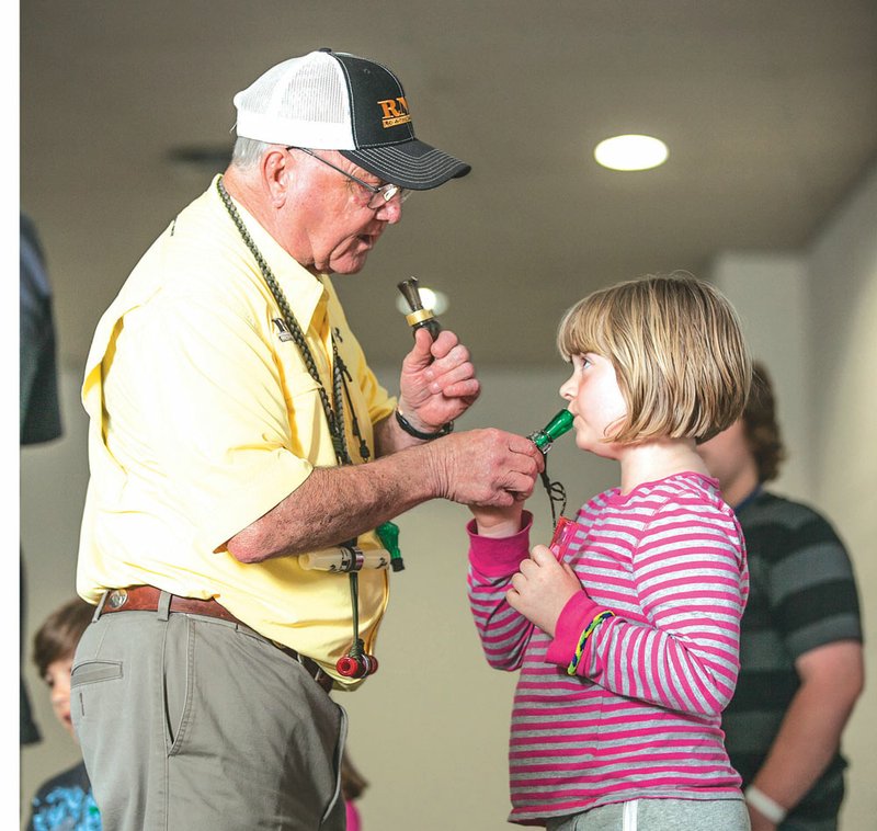 Rich-N-Tone creator Butch Richenback, left, teaches Chesney Hendricks the proper teqhnique for “the quack,” the first step in learning to call ducks.