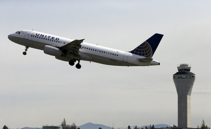 In this April 23, 2013 photo, a United Airlines jet departs in view of the air traffic control tower at Seattle-Tacoma International Airport in Seattle. With flight delays mounting, Congress approved hurry-up legislation Friday to end air traffic controller furloughs blamed for inconveniencing large numbers of travelers.