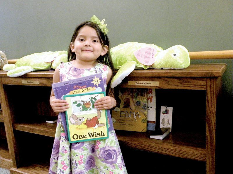 Brianna Matheu, the 5-year-old daughter of Juan Carlos Lopez and Gemil Lisseth Lopez of Conway, shows some of the books she will put in her personalized bookcase. Brianna is enrolled in the Community Action Program for Central Arkansas’ Head Start program and will attend kindergarten in the fall.