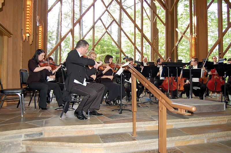 Members of the Arkansas Symphony Orchestra, led by co-concert master Kril Laskarov, front, warm up for a performance in Anthony Chapel at Garvan Woodland Gardens near Hot Springs. The group played to a sellout crowd in the glass-walled structure, surrounded by nature.