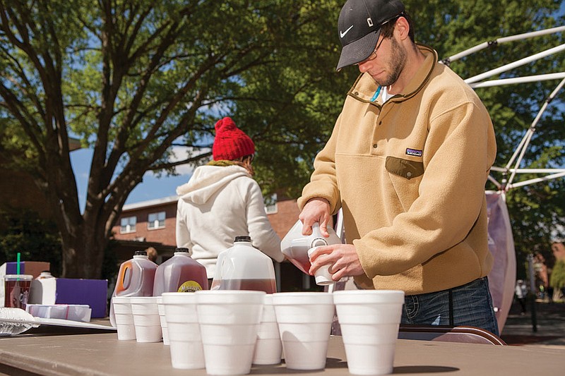John Marasco, a sophomore, pours tea to hand out while educating the University of Central Arkansas campus about how to make the most impact with their charitable giving. UCA students will also be taking donations for hunger relief (through Feed My Starving Children), shelter for the working homeless (through Our House of Little Rock) and clean water projects in Kenya (through Charity:Water).