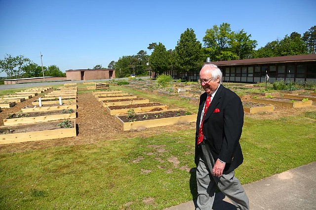 Bob Gee, a longtime member of First Christian Church, walks past the 90 boxes used for community gardening on the church grounds. 