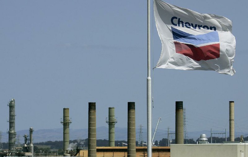 A Chevron flag flies over a company refinery in Richmond, Calif. Chevron said Friday that its net income fell 5 percent in the first quarter. 