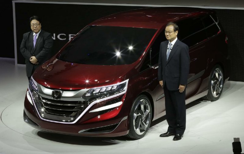 Honda Motor Co. President Takanobu Ito (right) and Seiji Kuraishi, president of Honda Motor’s China division, show off the company’s new Concept M at an automobile exhibition earlier this month in Shanghai. Honda reported a quarterly profit of $765 million on Friday. 