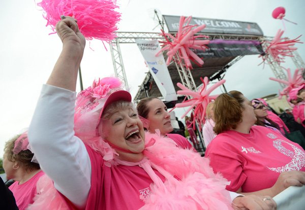 Candyce Hinkle, left, and her daughter Cara Stewart, center, both of Little Rock, participate Saturday in the survivor parade during the annual Komen Ozark Race for the Cure at the Pinnacle Hills Promenade in Rogers. Both Hinkle and Stewart are breast cancer survivors. 