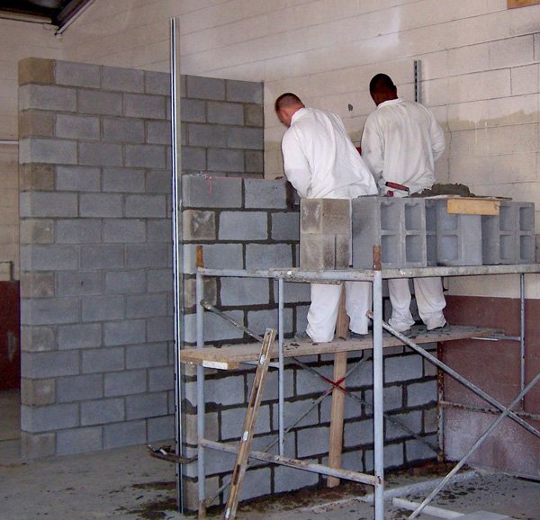 Prisoners from the Arkansas Department of Correction build a wall Thursday for an office in the Springdale Armory. The Northwest Arkansas Work Release Program will move to the armory, 600 W. Sunset Ave., and expand from 42 to 100 when renovation is complete. 