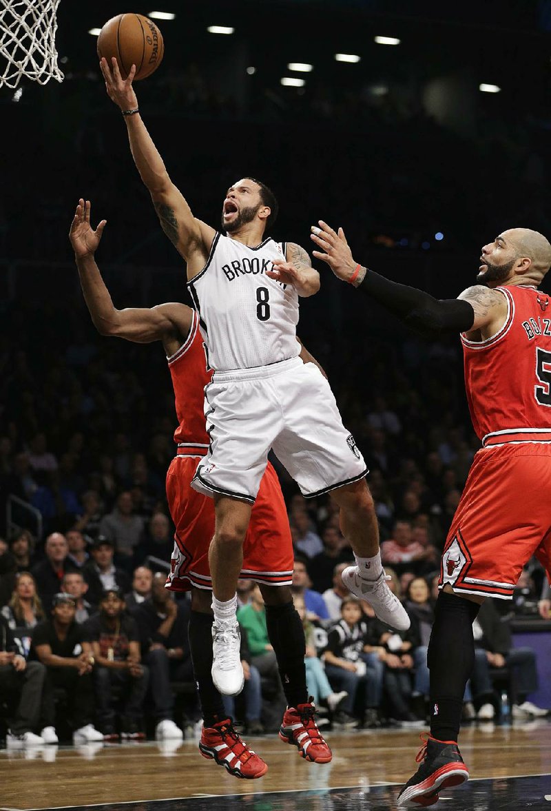Brooklyn Nets guard Deron Williams (8) goes up for a layup past Chicago Bulls forward Carlos Boozer (5) in the first half of Game 5 of their first-round NBA basketball playoff series, Monday, April 29, 2013, in New York. The Nets won 110-91. (AP Photo/Kathy Willens)