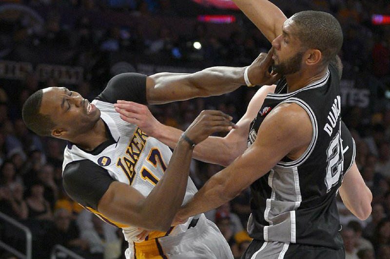 Los Angeles Lakers center Dwight Howard (left) and San Antonio Spurs forward Tim Duncan battle during Sunday’s game. The Spurs completed a first-round sweep with a 103-82 victory. 